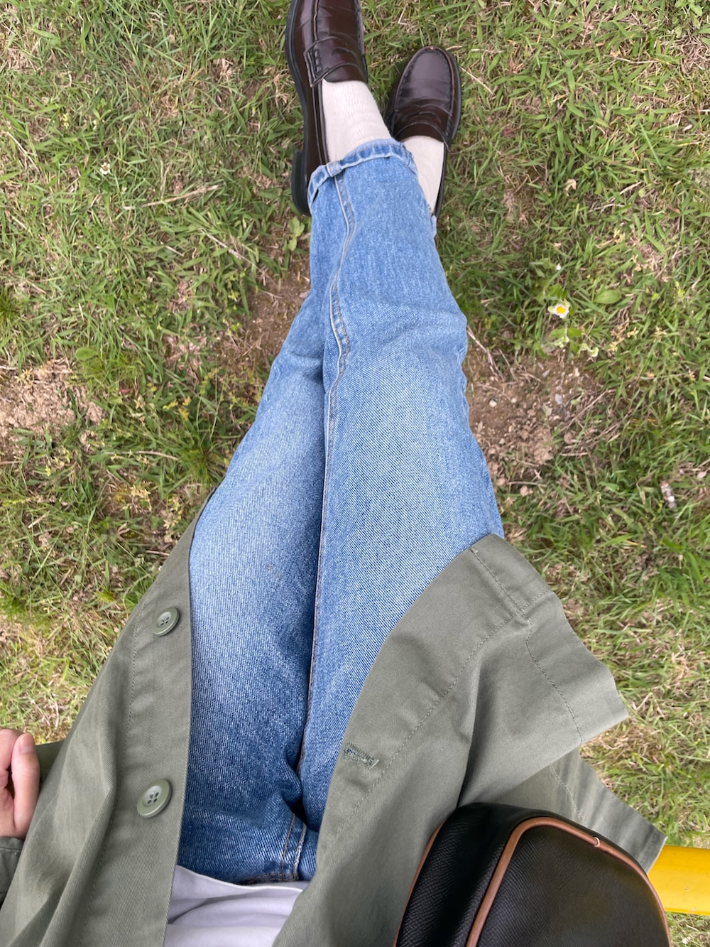 ブルー系のデニムパンツ、ブラック系のショルダーバッグ、ホワイト系のTシャツ/カットソーを着用したレディースの冬コーディネートの2枚目の写真