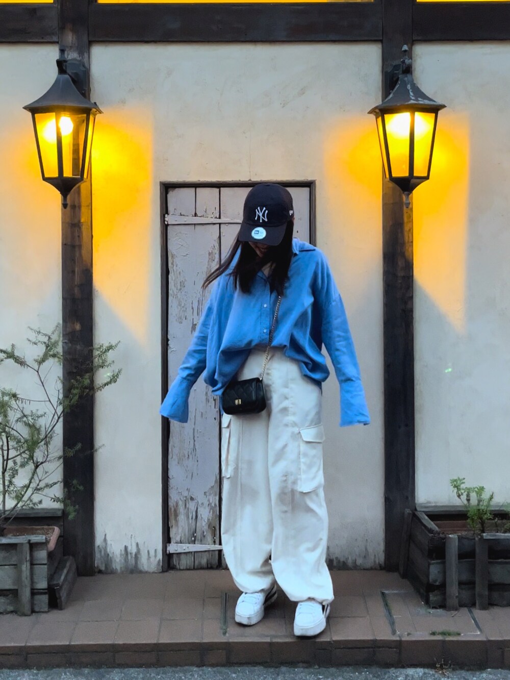 ブルー系のシャツ/ブラウス、ホワイト系のカーゴパンツ、ホワイト系のスニーカーを着用したレディースの春コーディネートの2枚目の写真