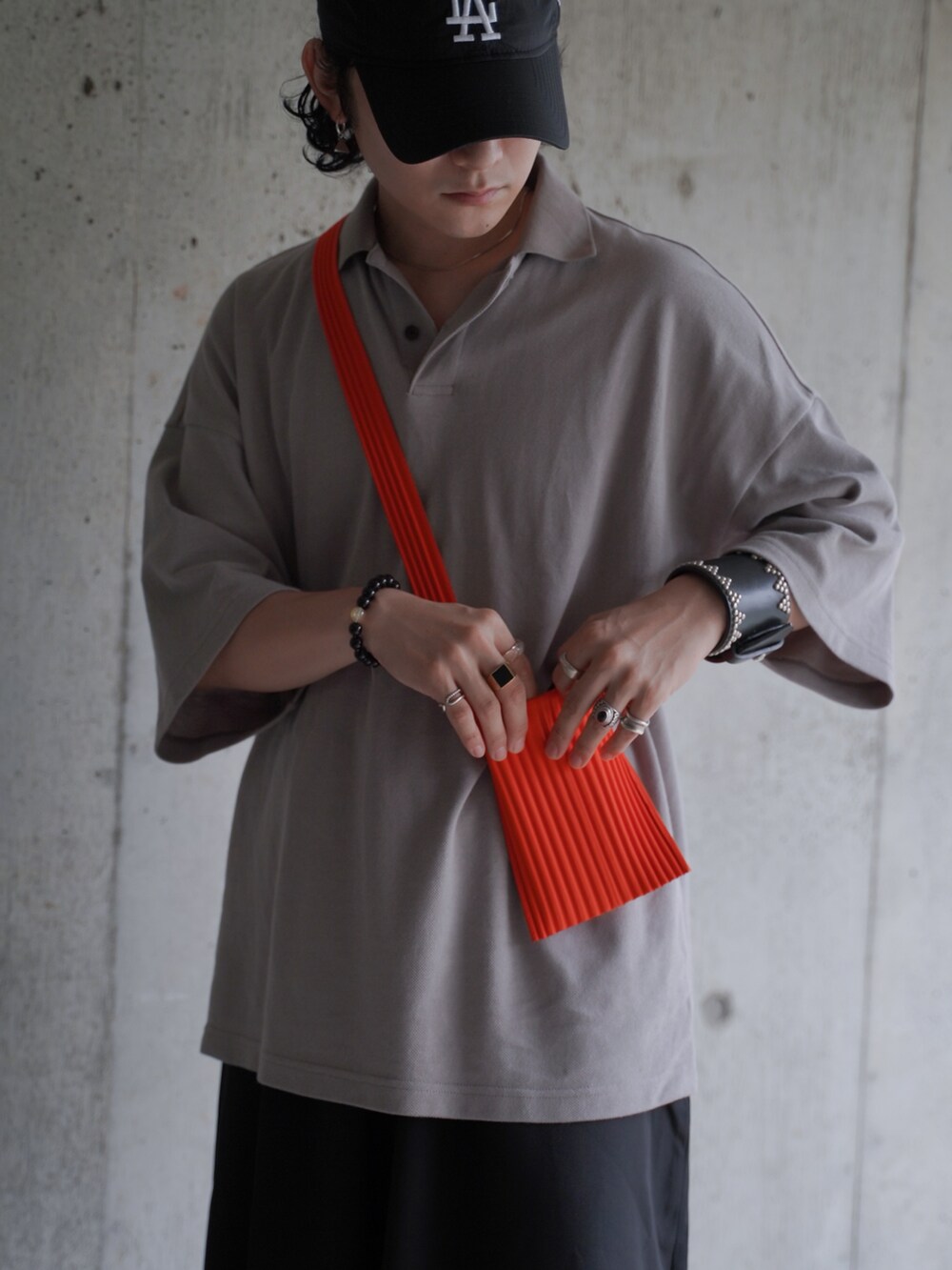 ブラック系のスラックス、ブラック系のサンダル、ベージュ系のポロシャツを着用したメンズの夏コーディネートの2枚目の写真