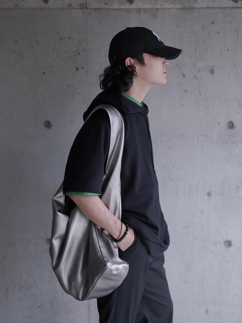 ブラック系のスラックス、ブラック系のパーカー、シルバー系のトートバッグを着用したメンズの夏コーディネートの2枚目の写真