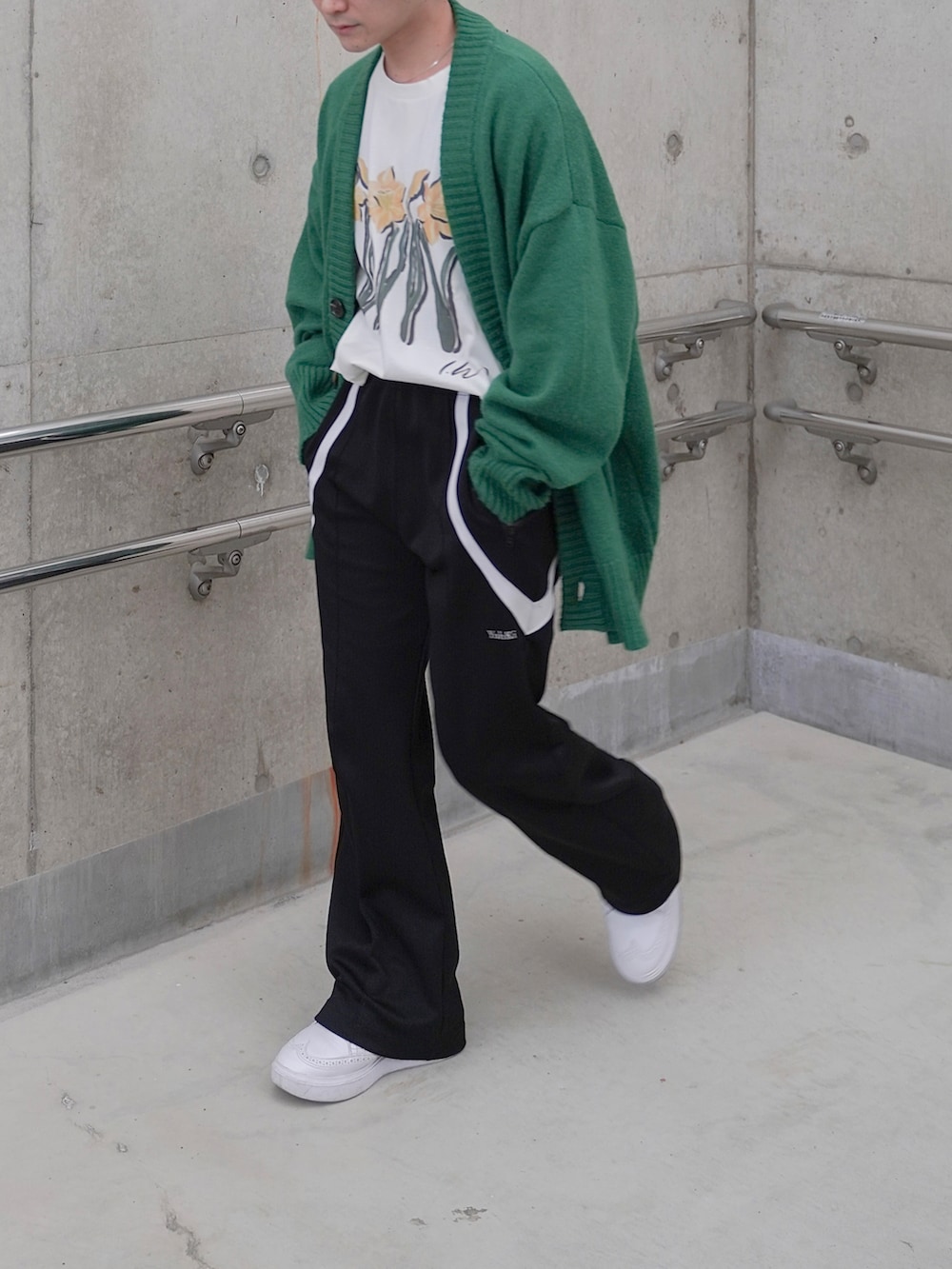 ブラック系のその他パンツ、グリーン系のニット/セーター、ホワイト系のTシャツ/カットソーを着用したメンズの春コーディネートの4枚目の写真