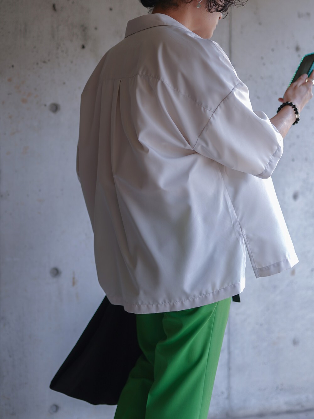 グリーン系のパンツ、ブラック系のバッグ、ホワイト系のTシャツ/カットソーを着用したメンズの夏コーディネートの3枚目の写真