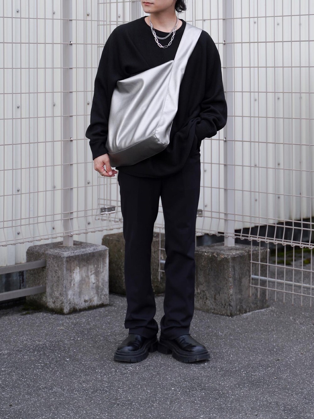 ブラック系のパンツ、ブラック系のブーツ、シルバー系のトートバッグを着用したメンズの秋コーディネートの2枚目の写真