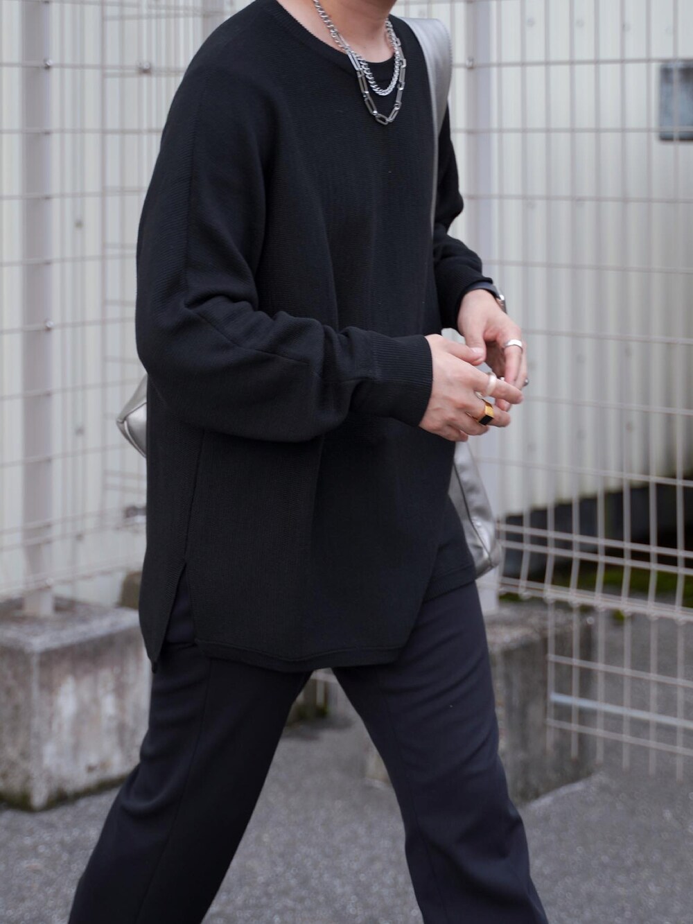 ブラック系のパンツ、ブラック系のブーツ、シルバー系のトートバッグを着用したメンズの秋コーディネートの4枚目の写真