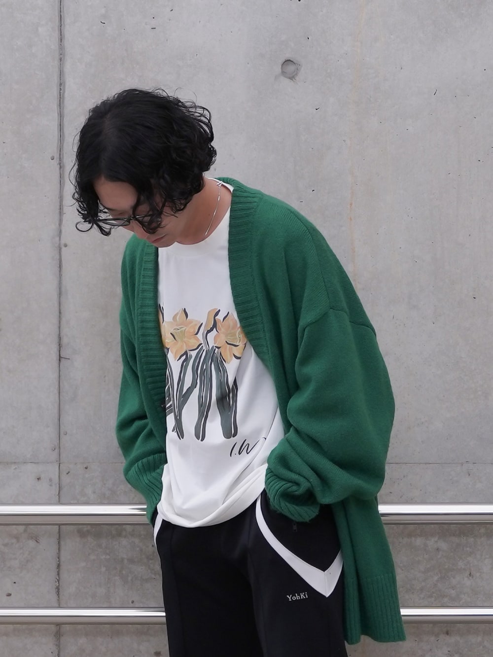 ブラック系のその他パンツ、グリーン系のニット/セーター、ホワイト系のTシャツ/カットソーを着用したメンズの春コーディネートの2枚目の写真