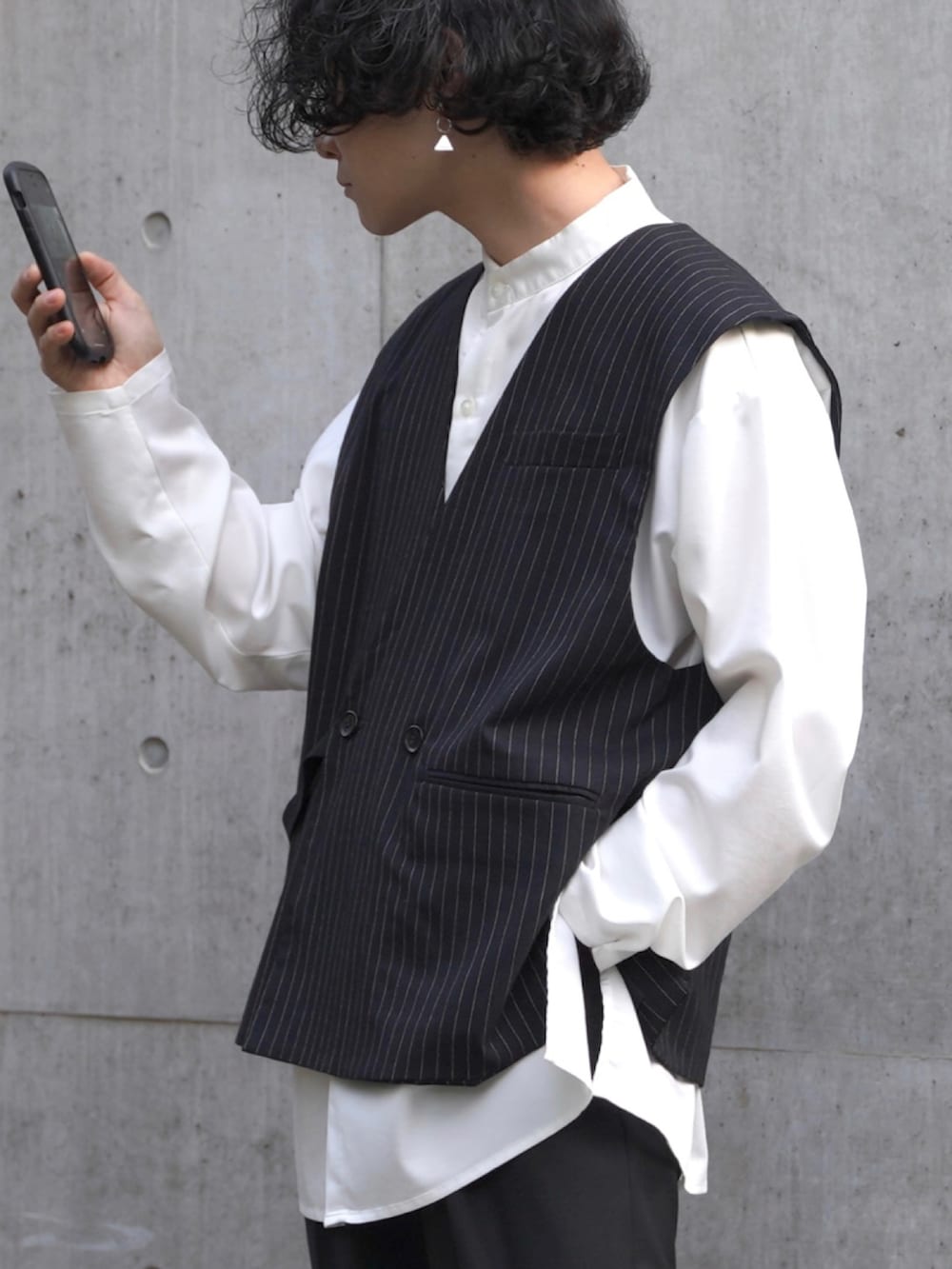 ブラック系のスラックス、ブラック系のシューズ、ホワイト系のシャツ/ブラウスを着用したメンズの春コーディネートの2枚目の写真