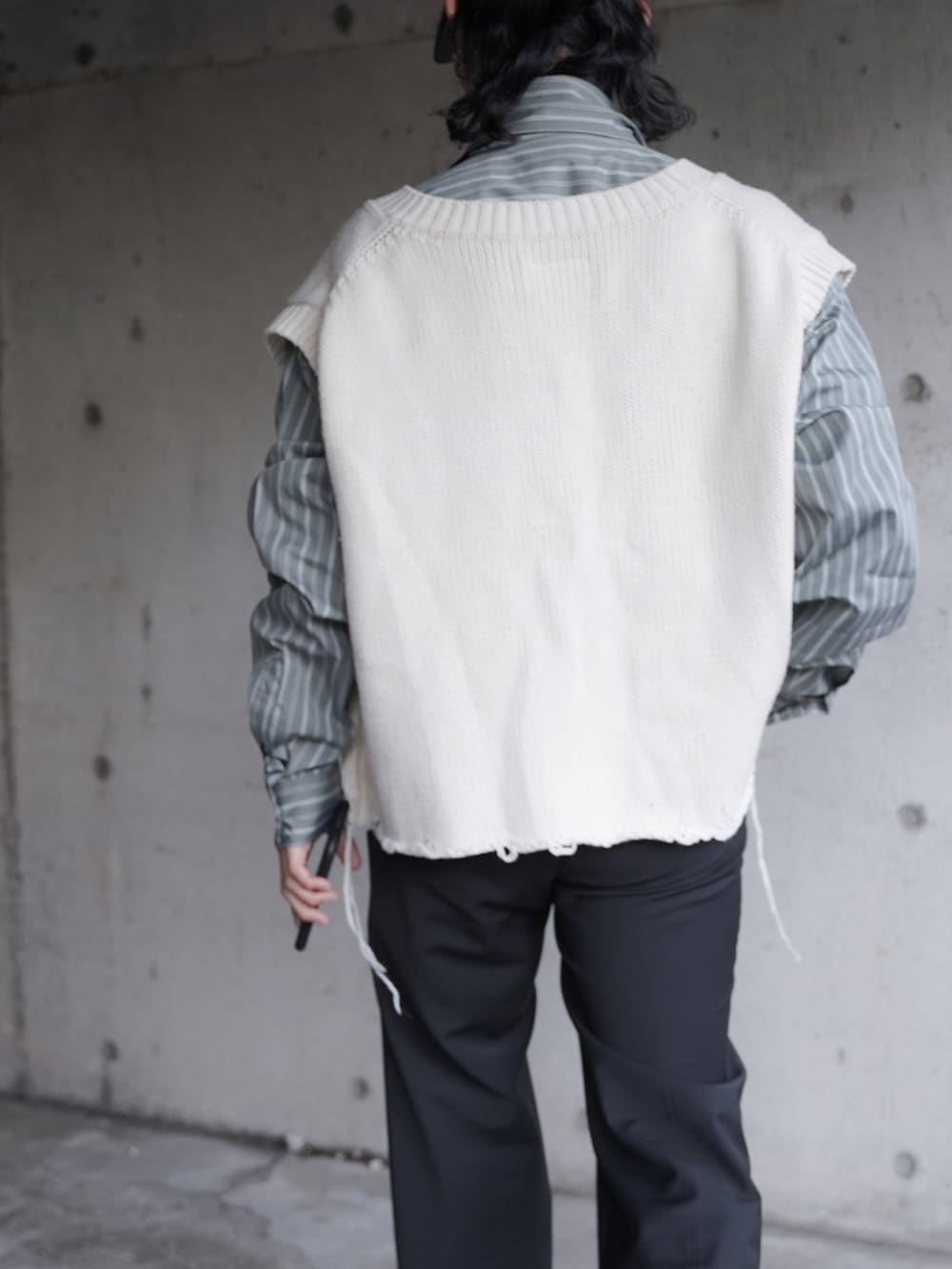 グリーン系のシャツ/ブラウス、ホワイト系のベスト、ブラック系のスラックスを着用したメンズの冬コーディネートの3枚目の写真