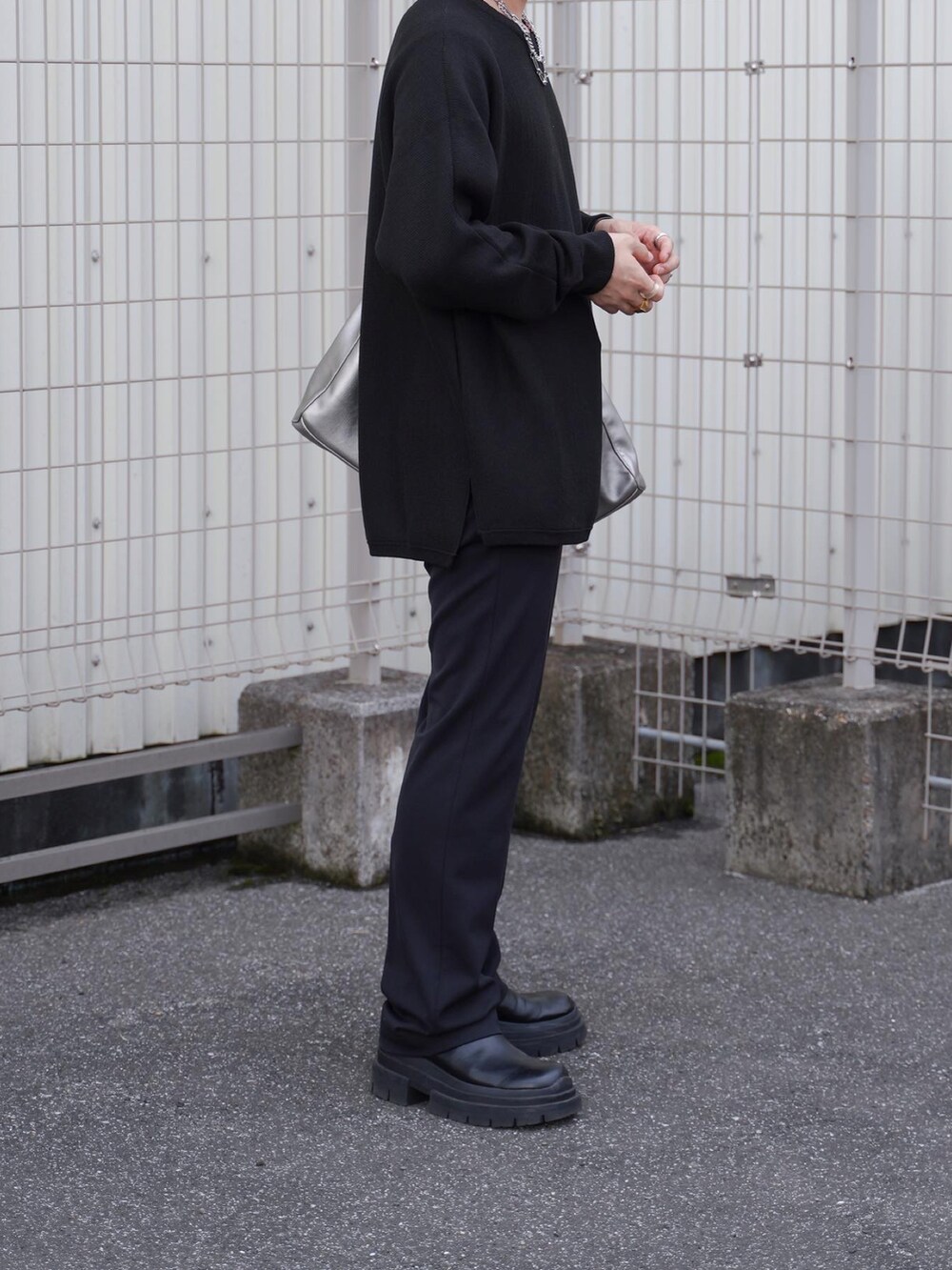 ブラック系のパンツ、ブラック系のブーツ、シルバー系のトートバッグを着用したメンズの秋コーディネートの3枚目の写真