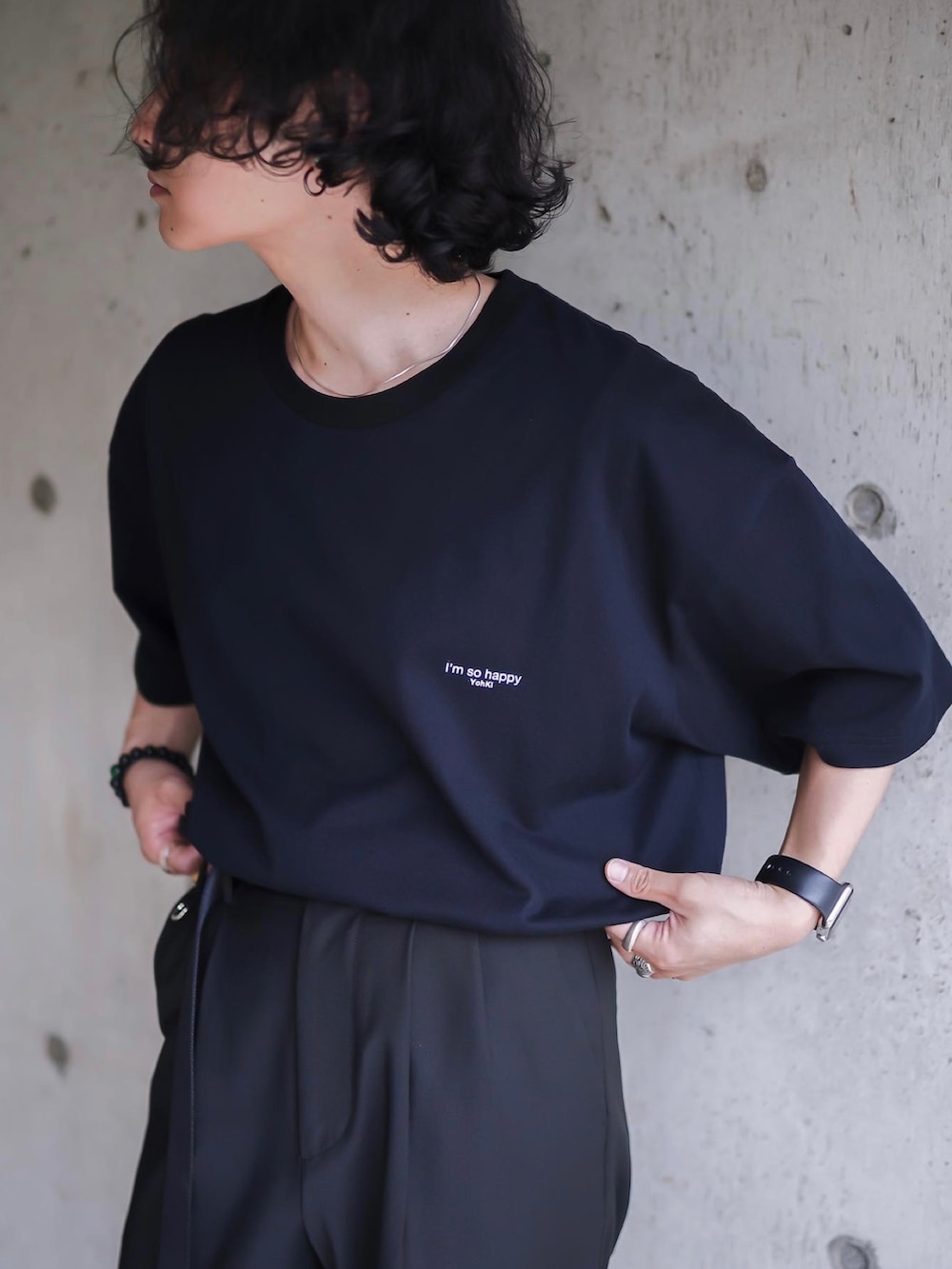 ブラック系のローファー、ブラック系のスラックス、ホワイト系のショルダーバッグを着用したメンズの夏コーディネートの3枚目の写真