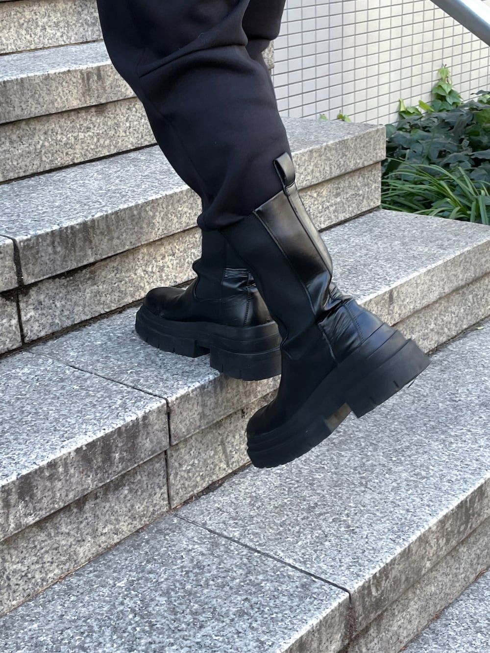 ブラック系のスウェットパンツ、ブラック系のパーカー、ブラック系のブーツを着用したメンズの冬コーディネートの3枚目の写真