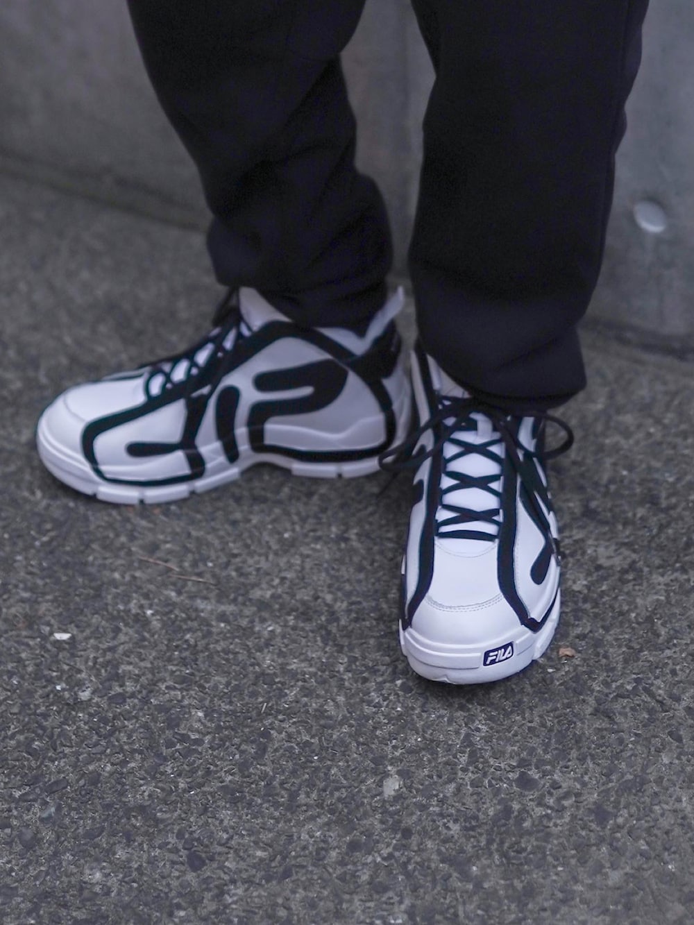 ホワイト系のスニーカー、ブラック系のスウェットパンツ、ホワイト系のTシャツ/カットソーを着用したメンズの夏コーディネートの3枚目の写真