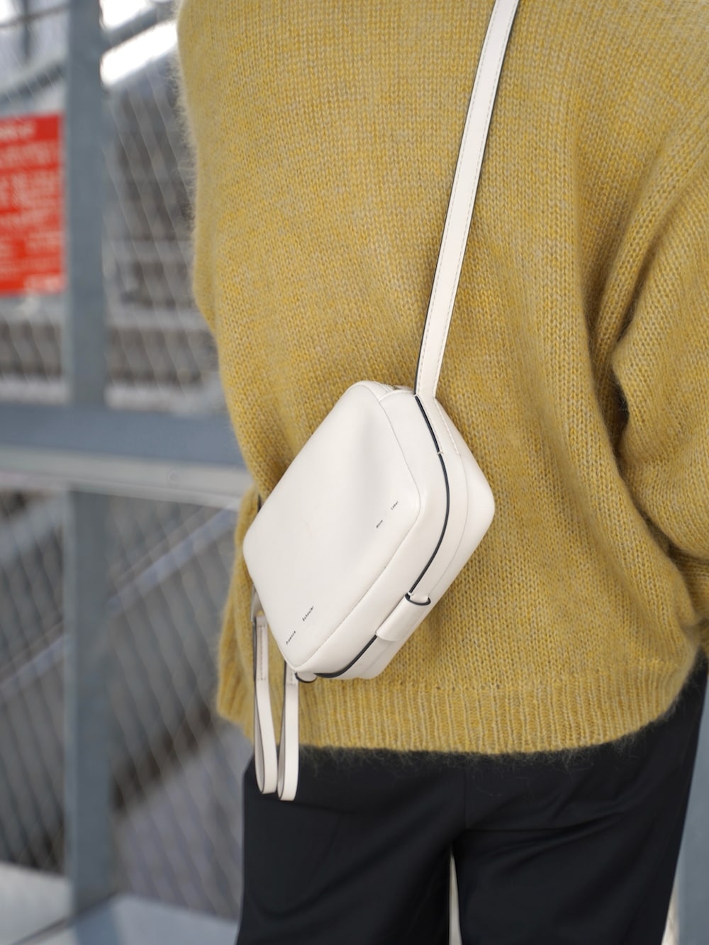 ホワイト系のショルダーバッグ、イエロー系のカーディガン/ボレロ、ホワイト系のTシャツ/カットソーを着用したメンズの秋コーディネートの3枚目の写真