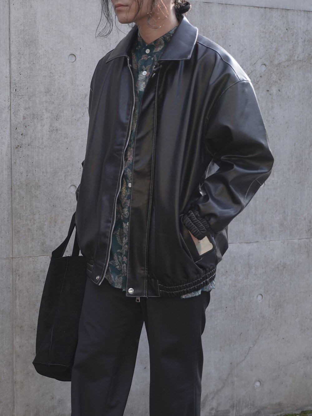 ブラック系のジャケット/アウター、ブラック系のトートバッグ、ブラック系のスラックスを着用したメンズの春コーディネートの3枚目の写真