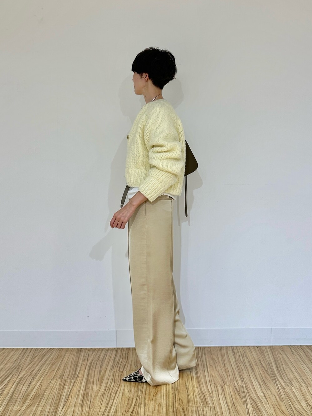 イエロー系のカーディガン/ボレロ、ホワイト系のTシャツ/カットソー、ベージュ系のその他パンツを着用したレディースの秋コーディネートの5枚目の写真