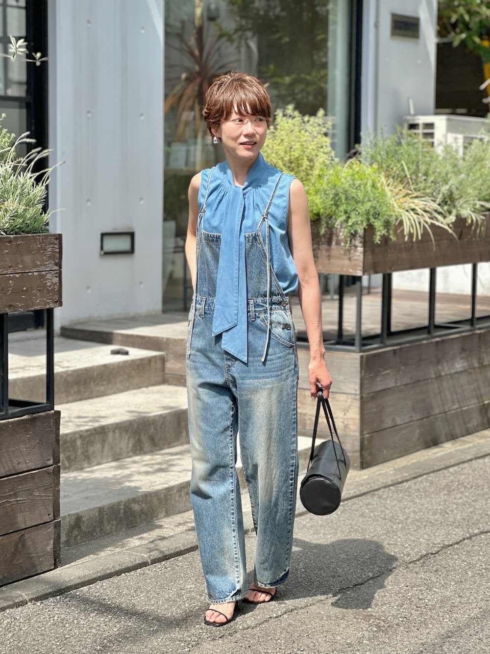 ブルー系のつなぎ/オールインワン、ブラック系のハンドバッグを着用したレディースの春コーディネートの4枚目の写真