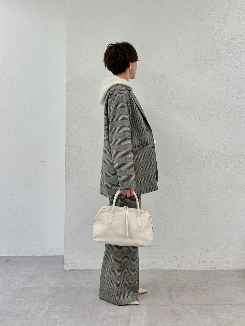 ベージュ系のニット/セーター、ホワイト系のトートバッグ、ベージュ系のパンプスを着用したレディースの秋コーディネートの3枚目の写真