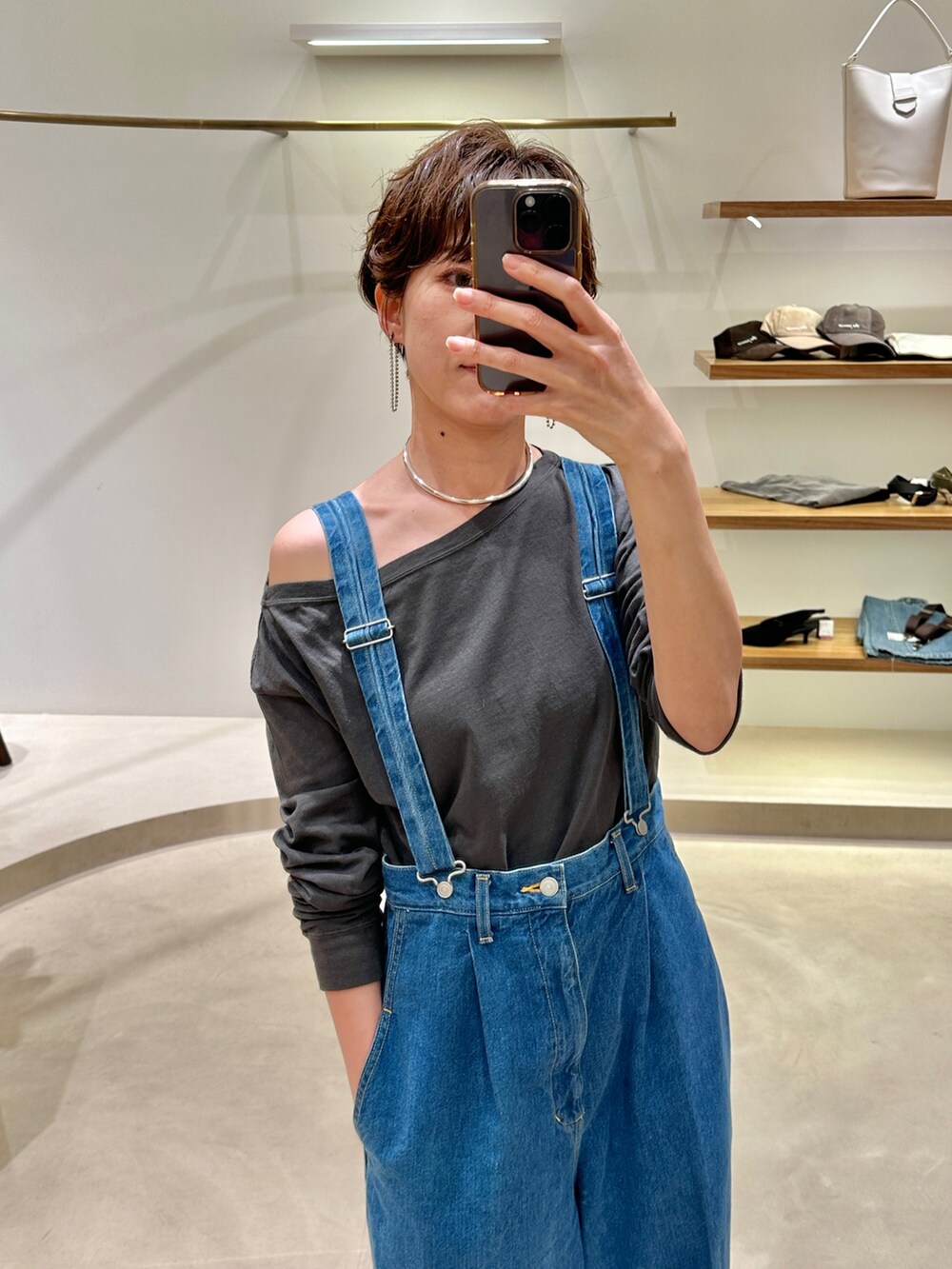 グレー系のTシャツ/カットソー、ブルー系のデニムパンツ、シルバー系のピアス（両耳用）を着用したレディースの冬コーディネートの2枚目の写真