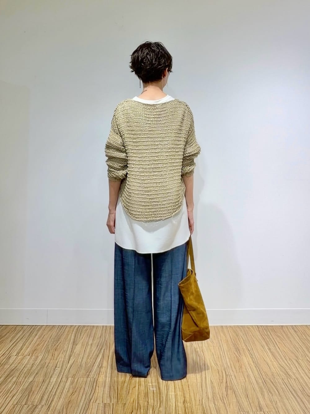 ホワイト系のシャツ/ブラウス、ベージュ系のニット/セーター、ブラウン系のトートバッグを着用したレディースの冬コーディネートの4枚目の写真