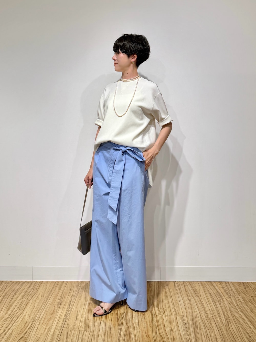 ホワイト系のシャツ/ブラウス、ブルー系のその他パンツ、ブラウン系のショルダーバッグを着用したレディースの春コーディネートの2枚目の写真
