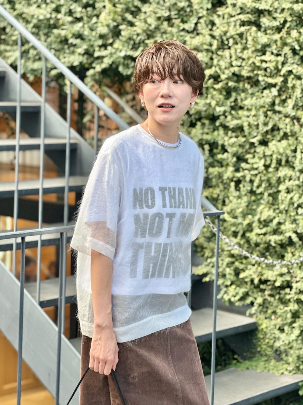 ブラック系のブーツ、ホワイト系のTシャツ/カットソー、ブラウン系のデニムスカートを着用したレディースの夏コーディネートの5枚目の写真