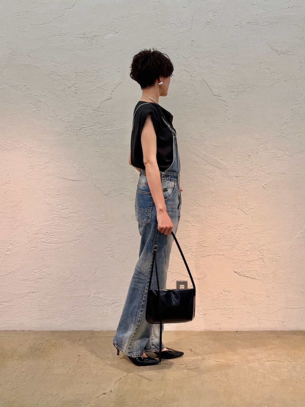ブルー系のつなぎ/オールインワン、ブラック系のシャツ/ブラウス、ブラック系のショルダーバッグを着用したレディースの春コーディネートの3枚目の写真