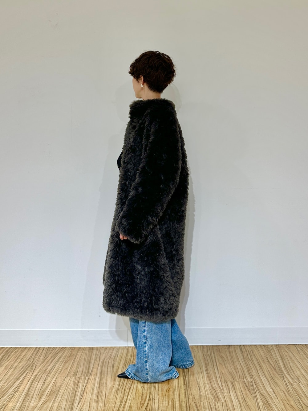 ブラック系のパンプス、ブルー系のデニムパンツ、グレー系のその他アウターを着用したレディースの秋コーディネートの5枚目の写真