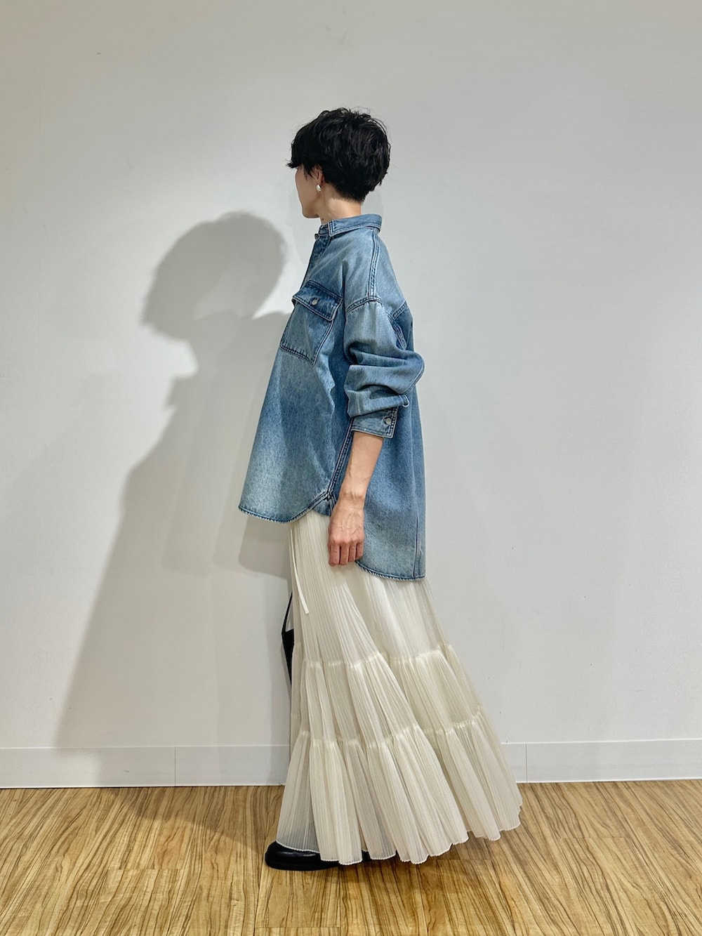 ブルー系のシャツ/ブラウス、ホワイト系のスカート、ブラウン系のショルダーバッグを着用したレディースの冬コーディネートの5枚目の写真