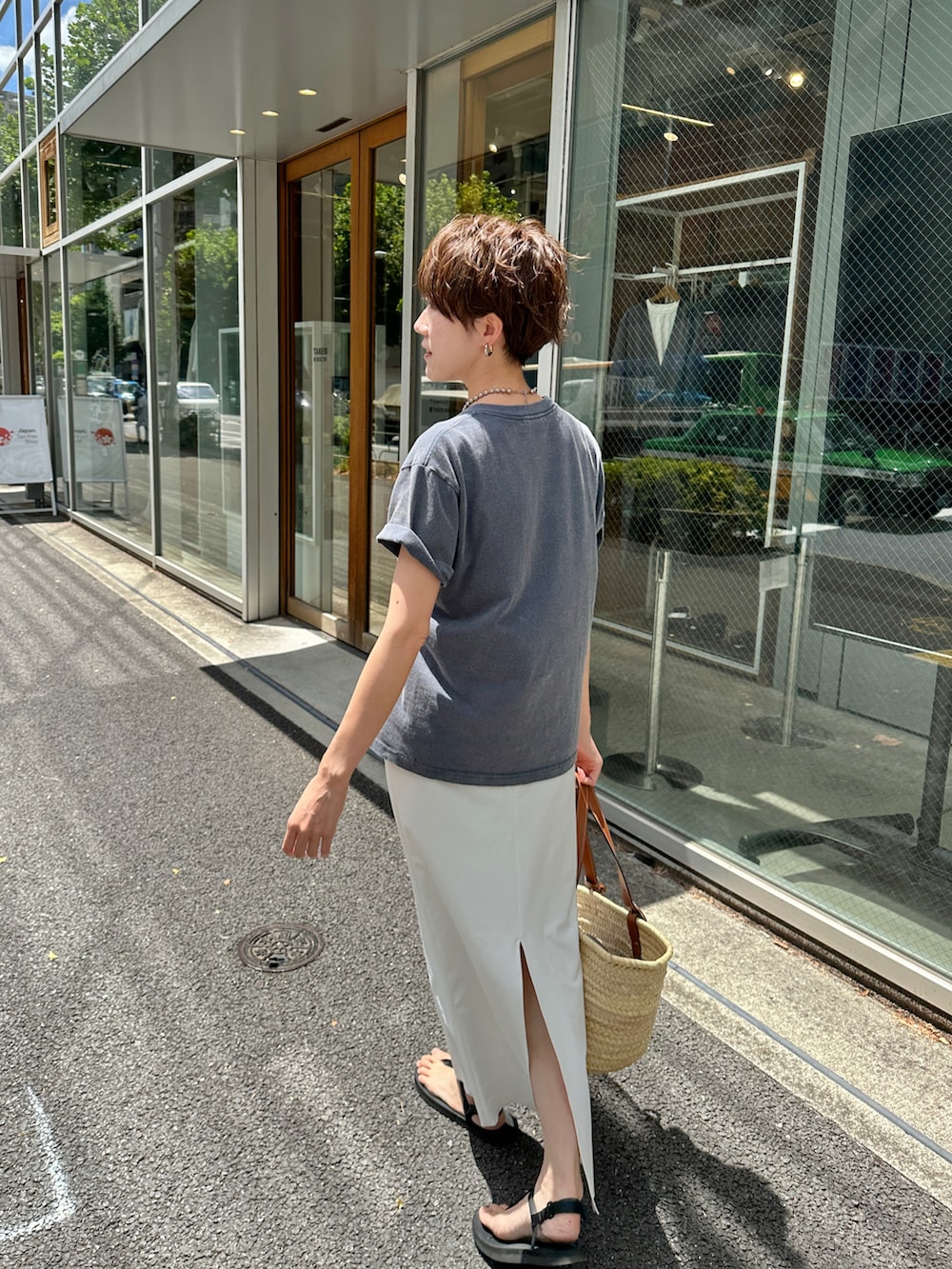 ブルー系のTシャツ/カットソー、ベージュ系のバッグ、ホワイト系のスカートを着用したレディースの夏コーディネートの4枚目の写真