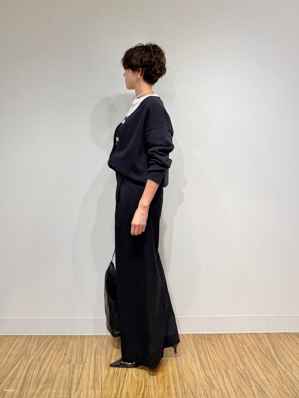 ブラック系のカーディガン/ボレロ、ホワイト系のTシャツ/カットソー、ブラック系のその他パンツを着用したレディースの冬コーディネートの5枚目の写真