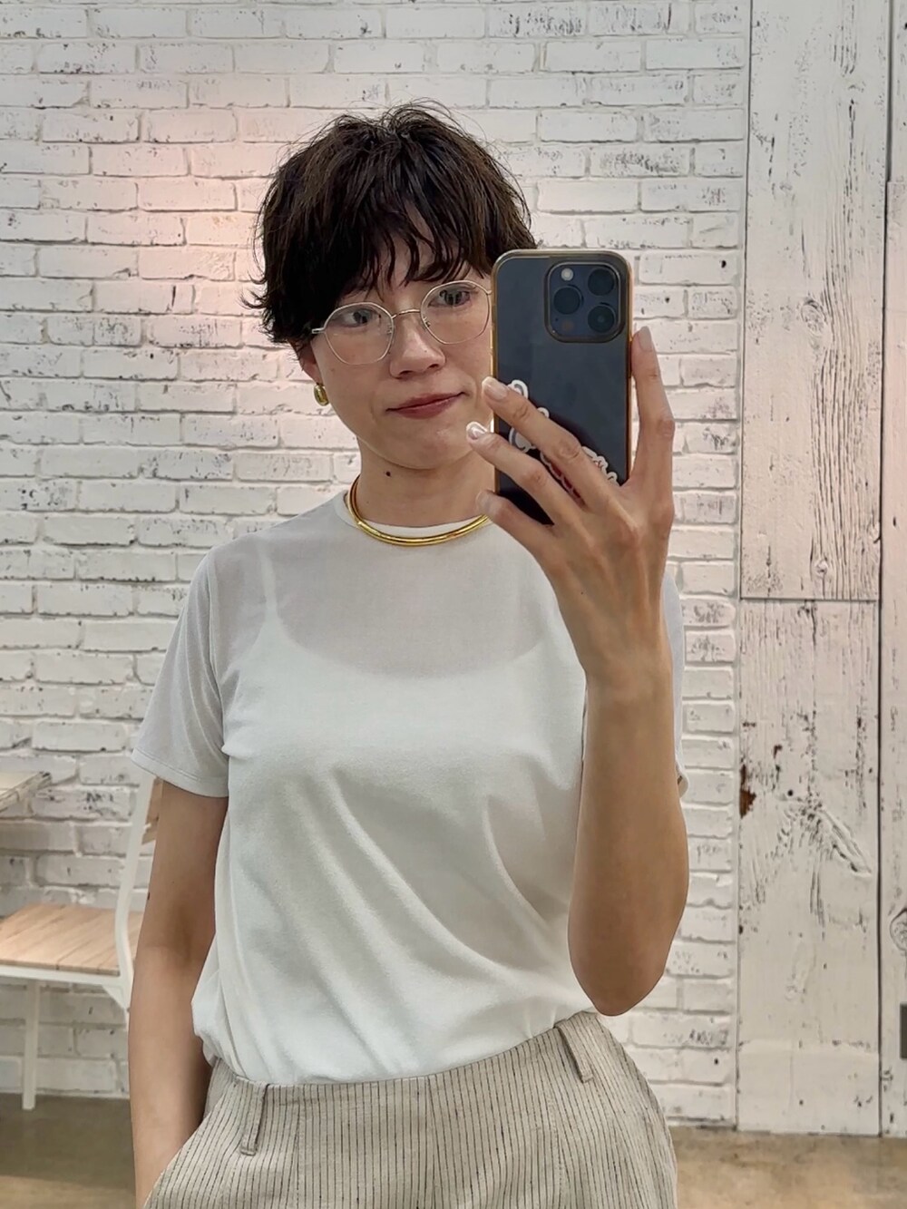 ホワイト系のTシャツ/カットソー、ゴールド系のチョーカー、ブラック系のサングラスを着用したレディースの春コーディネートの3枚目の写真