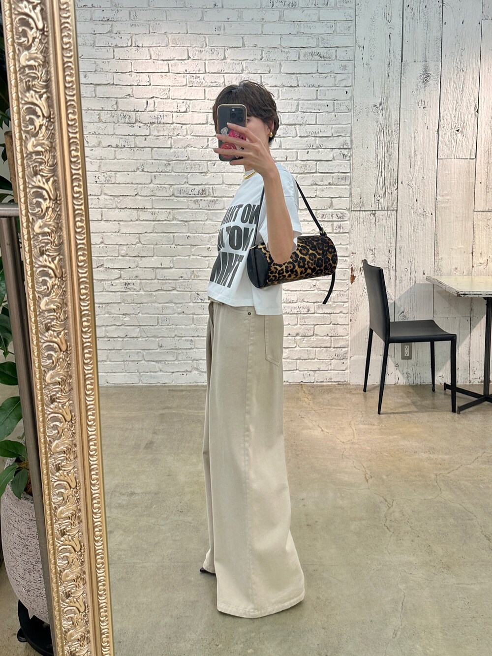 ブラウン系のパンプス、ホワイト系のTシャツ/カットソー、ベージュ系のデニムパンツを着用したレディースの夏コーディネートの2枚目の写真