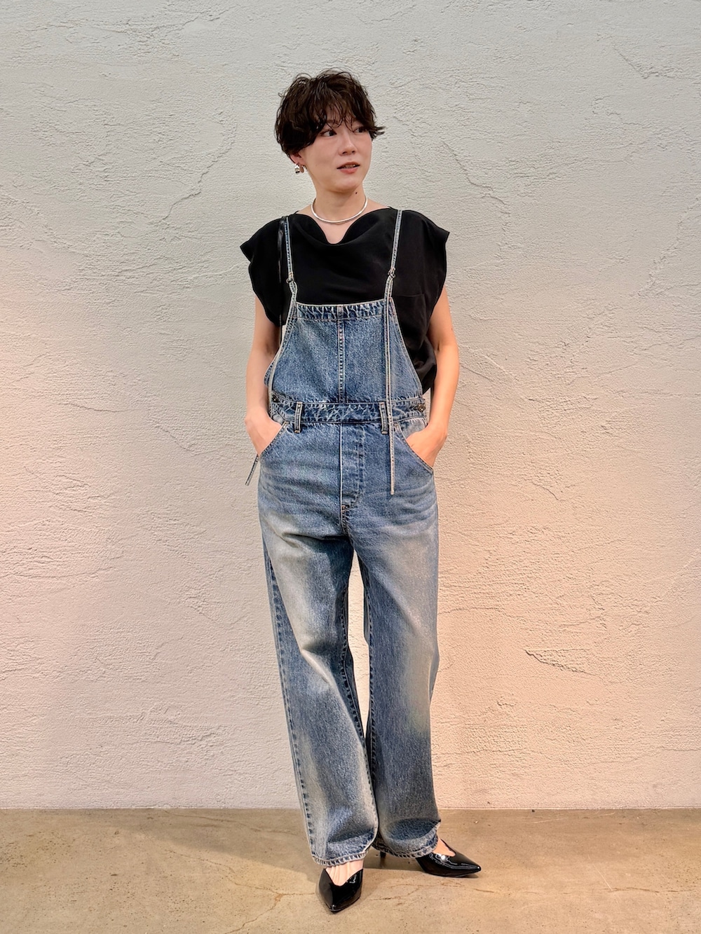 ブルー系のつなぎ/オールインワン、ブラック系のシャツ/ブラウス、ブラック系のショルダーバッグを着用したレディースの春コーディネートの2枚目の写真