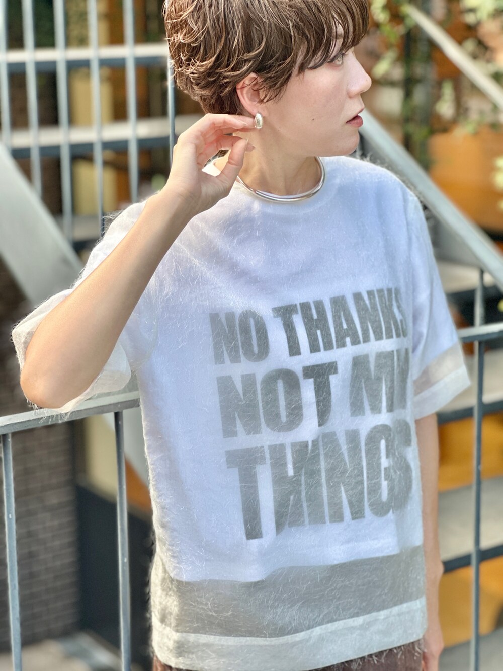 ブラック系のブーツ、ホワイト系のTシャツ/カットソー、ブラウン系のデニムスカートを着用したレディースの夏コーディネートの8枚目の写真