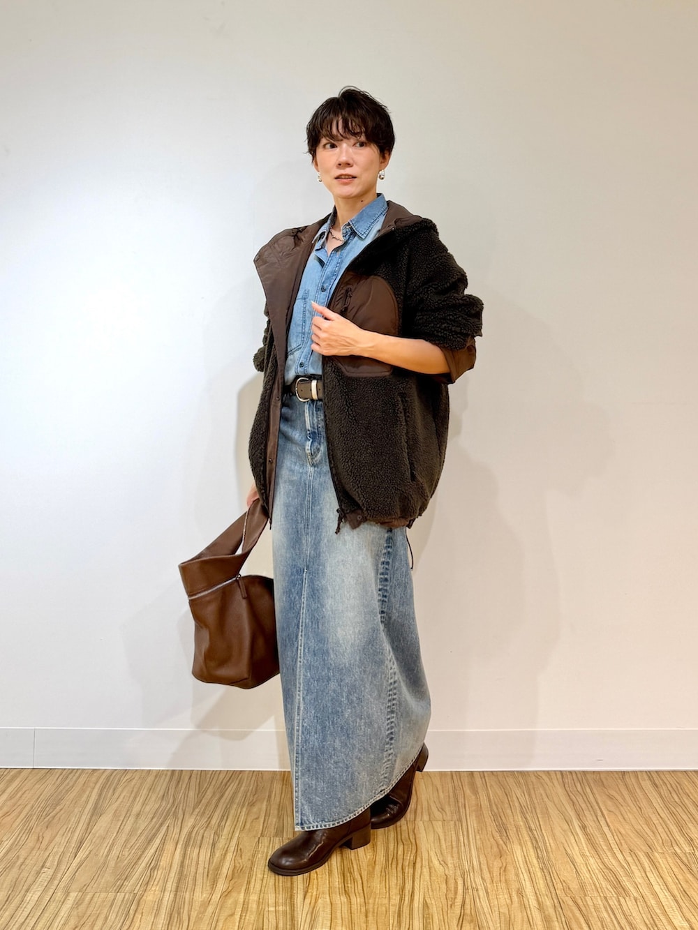 ブラウン系のブルゾン、ブルー系のシャツ/ブラウス、ブルー系のデニムスカートを着用したレディースの夏コーディネートの2枚目の写真