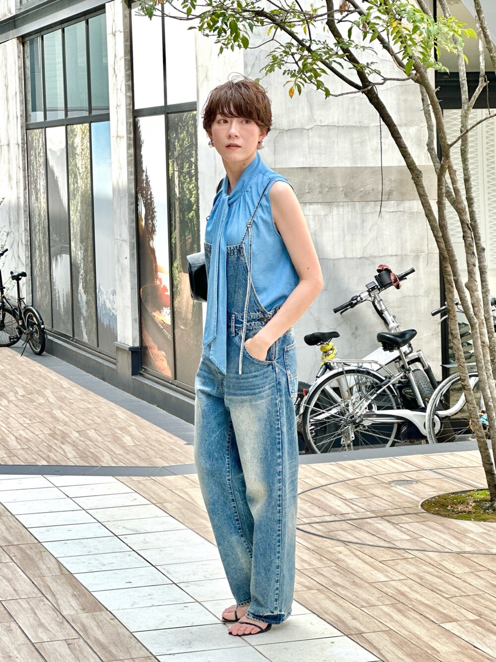 ブルー系のつなぎ/オールインワン、ブラック系のハンドバッグを着用したレディースの春コーディネートの2枚目の写真