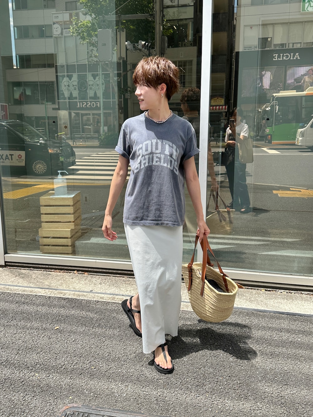 ブルー系のTシャツ/カットソー、ベージュ系のバッグ、ホワイト系のスカートを着用したレディースの夏コーディネートの3枚目の写真