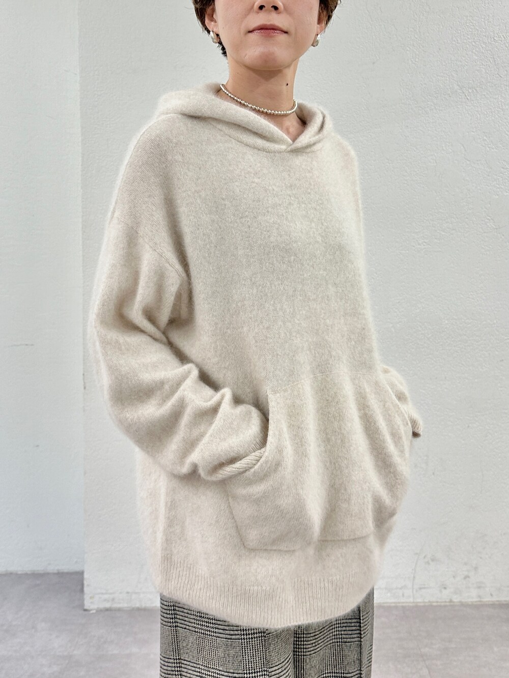 ベージュ系のニット/セーター、ホワイト系のトートバッグ、ベージュ系のパンプスを着用したレディースの秋コーディネートの6枚目の写真