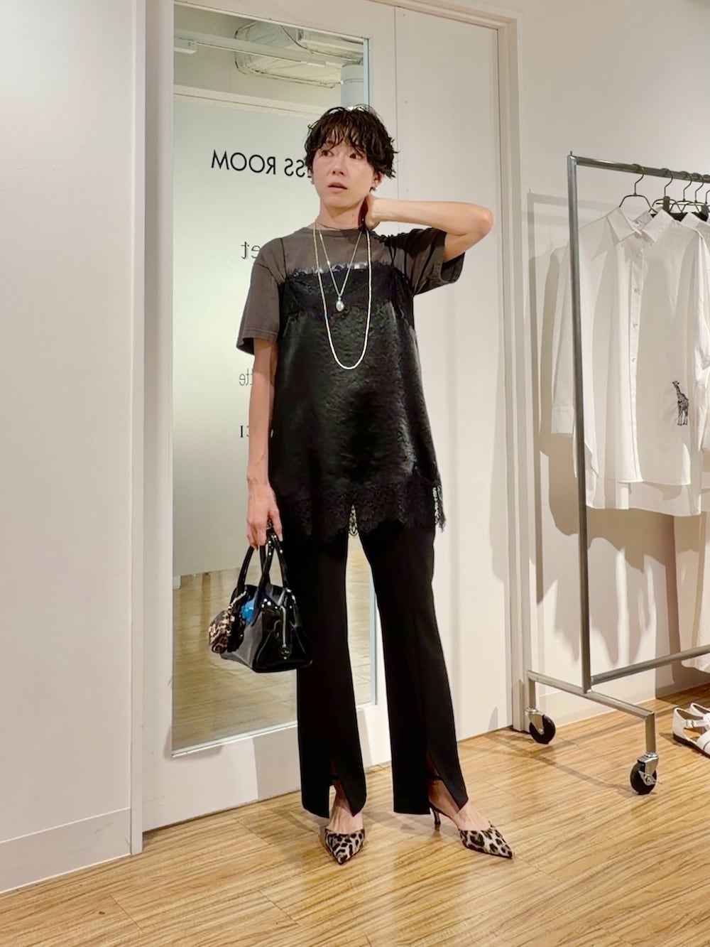 グレー系のTシャツ/カットソー、ブラック系のキャミソール、ブラック系のスラックスを着用したレディースの春コーディネートの2枚目の写真
