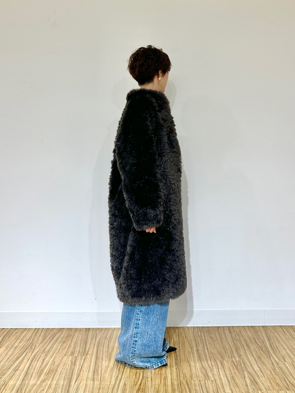 ブラック系のパンプス、ブルー系のデニムパンツ、グレー系のその他アウターを着用したレディースの秋コーディネートの3枚目の写真