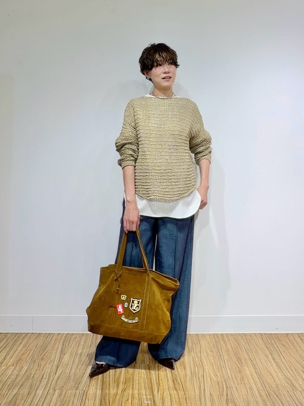 ホワイト系のシャツ/ブラウス、ベージュ系のニット/セーター、ブラウン系のトートバッグを着用したレディースの冬コーディネートの6枚目の写真