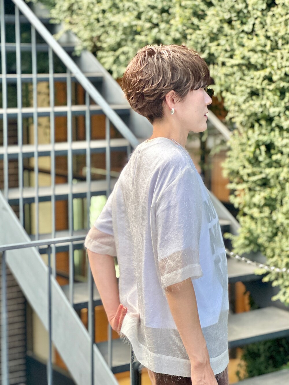 ブラック系のブーツ、ホワイト系のTシャツ/カットソー、ブラウン系のデニムスカートを着用したレディースの夏コーディネートの6枚目の写真