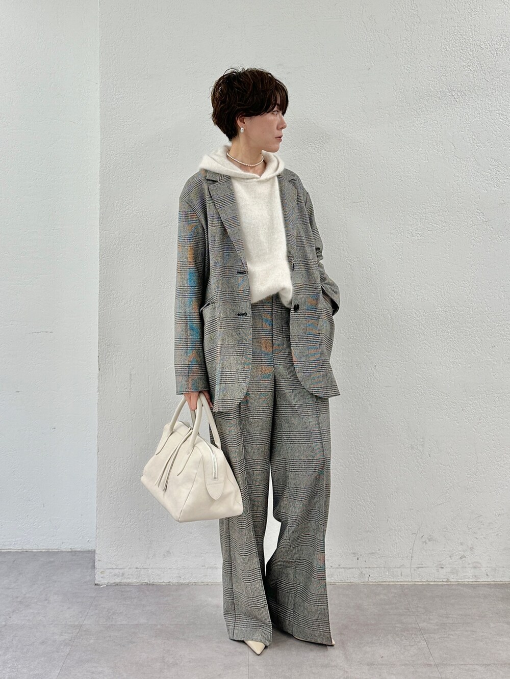 ベージュ系のニット/セーター、ホワイト系のトートバッグ、ベージュ系のパンプスを着用したレディースの秋コーディネートの2枚目の写真