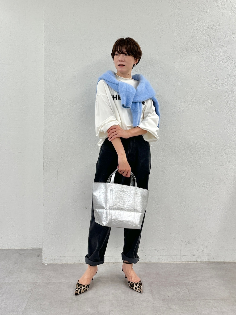 ホワイト系のTシャツ/カットソー、ベージュ系のニット/セーター、シルバー系のトートバッグを着用したレディースの秋コーディネートの2枚目の写真