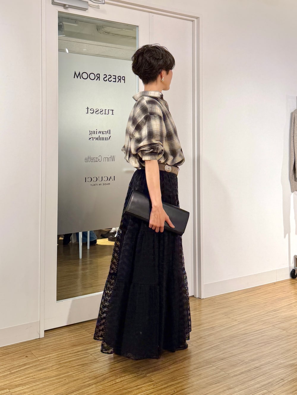ブラック系のスカート、ベージュ系のシャツ/ブラウス、ホワイト系のTシャツ/カットソーを着用したレディースの秋コーディネートの3枚目の写真