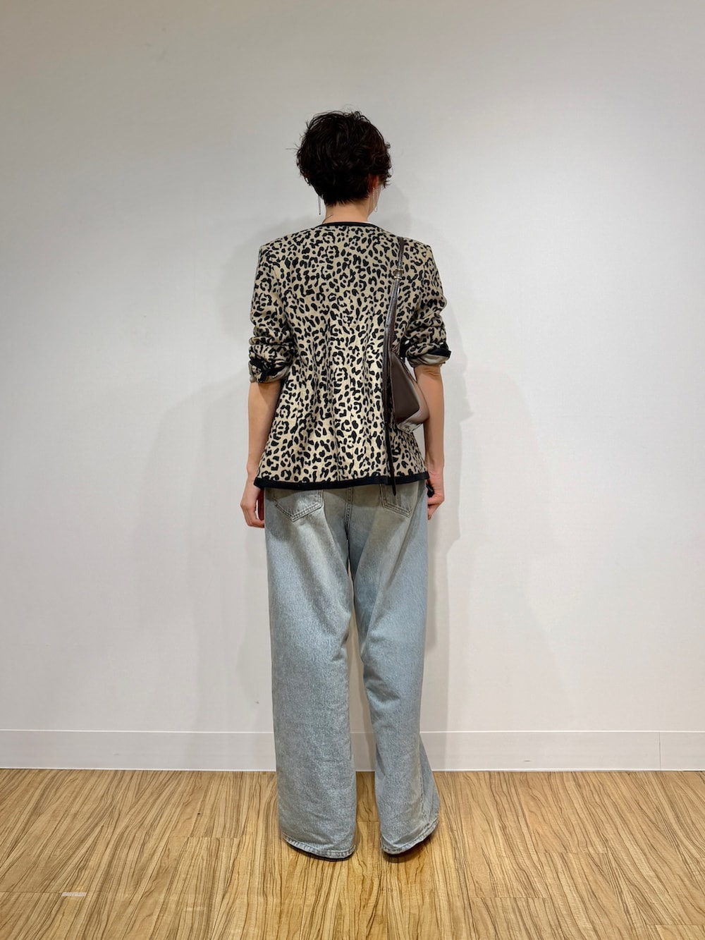 ブラック系のノーカラージャケット、ホワイト系のTシャツ/カットソー、ブルー系のデニムパンツを着用したレディースの冬コーディネートの4枚目の写真