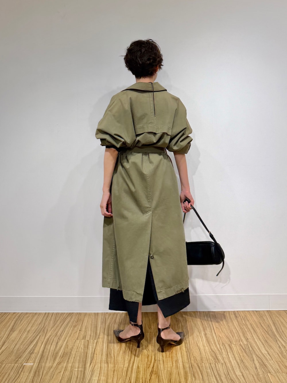 グリーン系のその他アウター、ブラック系のワンピース、ブラウン系のパンプスを着用したレディースの冬コーディネートの4枚目の写真