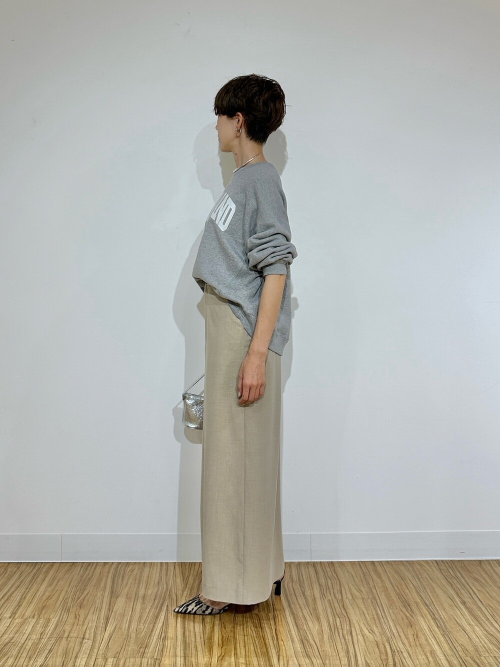 グレー系のスウェット、ベージュ系のスカート、イエロー系のパンプスを着用したレディースの冬コーディネートの5枚目の写真