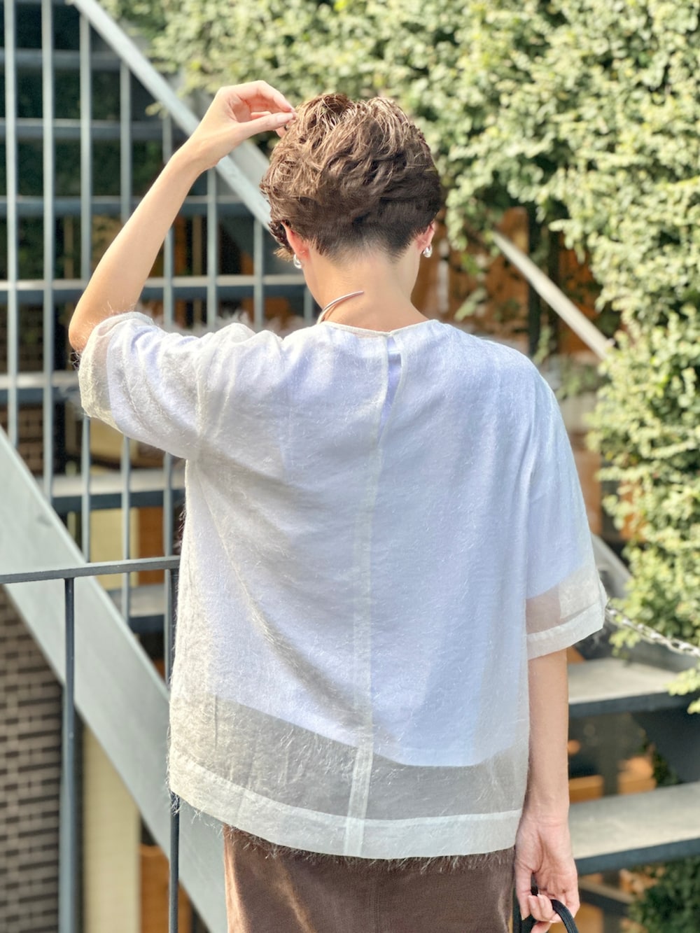 ブラック系のブーツ、ホワイト系のTシャツ/カットソー、ブラウン系のデニムスカートを着用したレディースの夏コーディネートの7枚目の写真