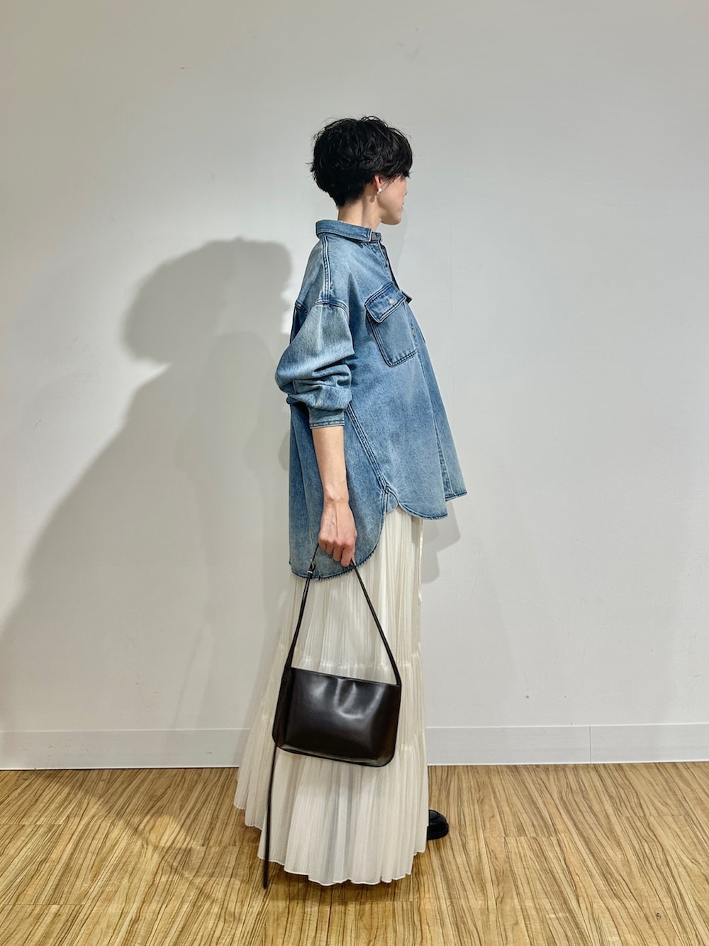 ブルー系のシャツ/ブラウス、ホワイト系のスカート、ブラウン系のショルダーバッグを着用したレディースの冬コーディネートの3枚目の写真