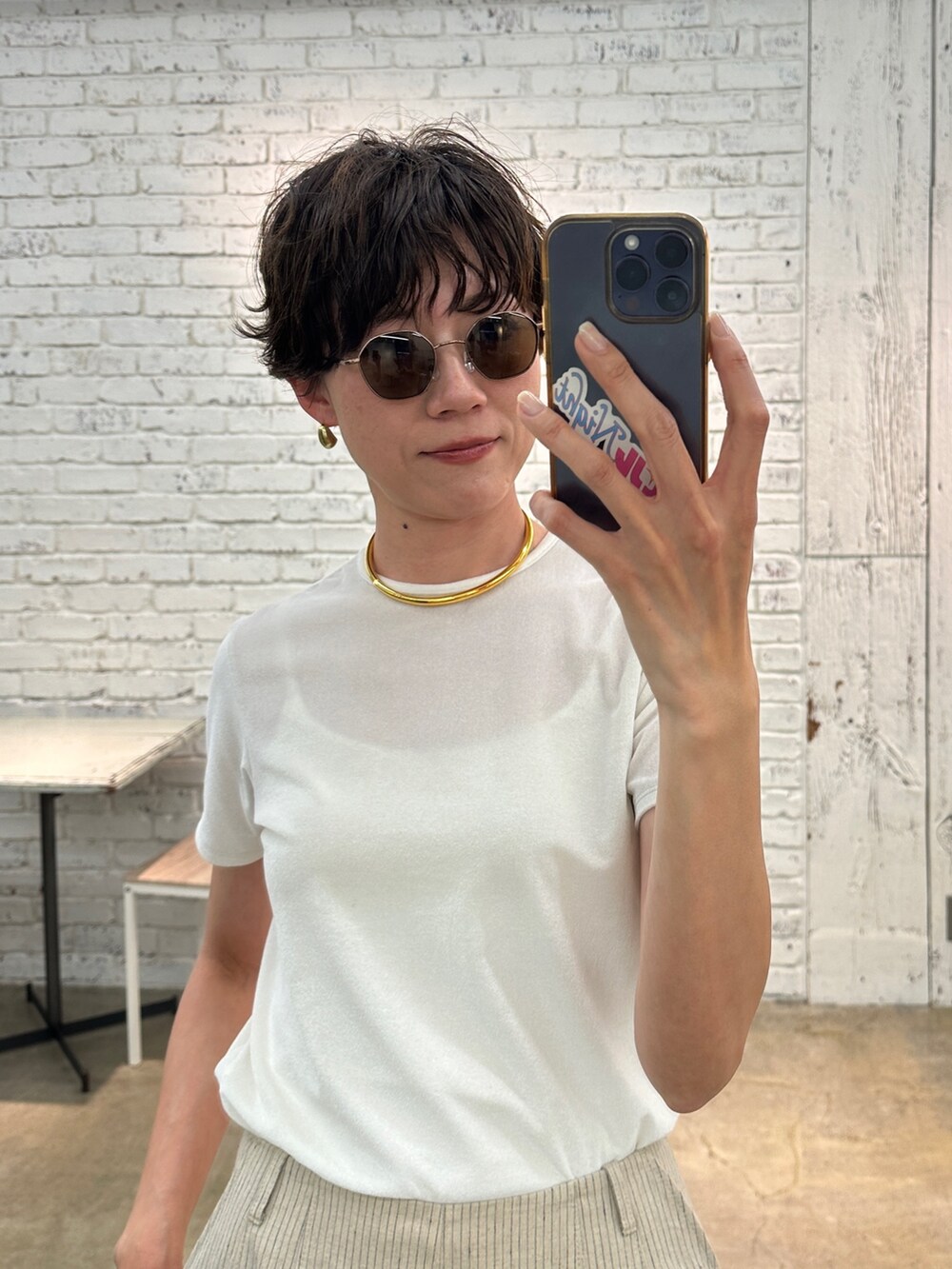 ホワイト系のTシャツ/カットソー、ゴールド系のチョーカー、ブラック系のサングラスを着用したレディースの春コーディネートの2枚目の写真